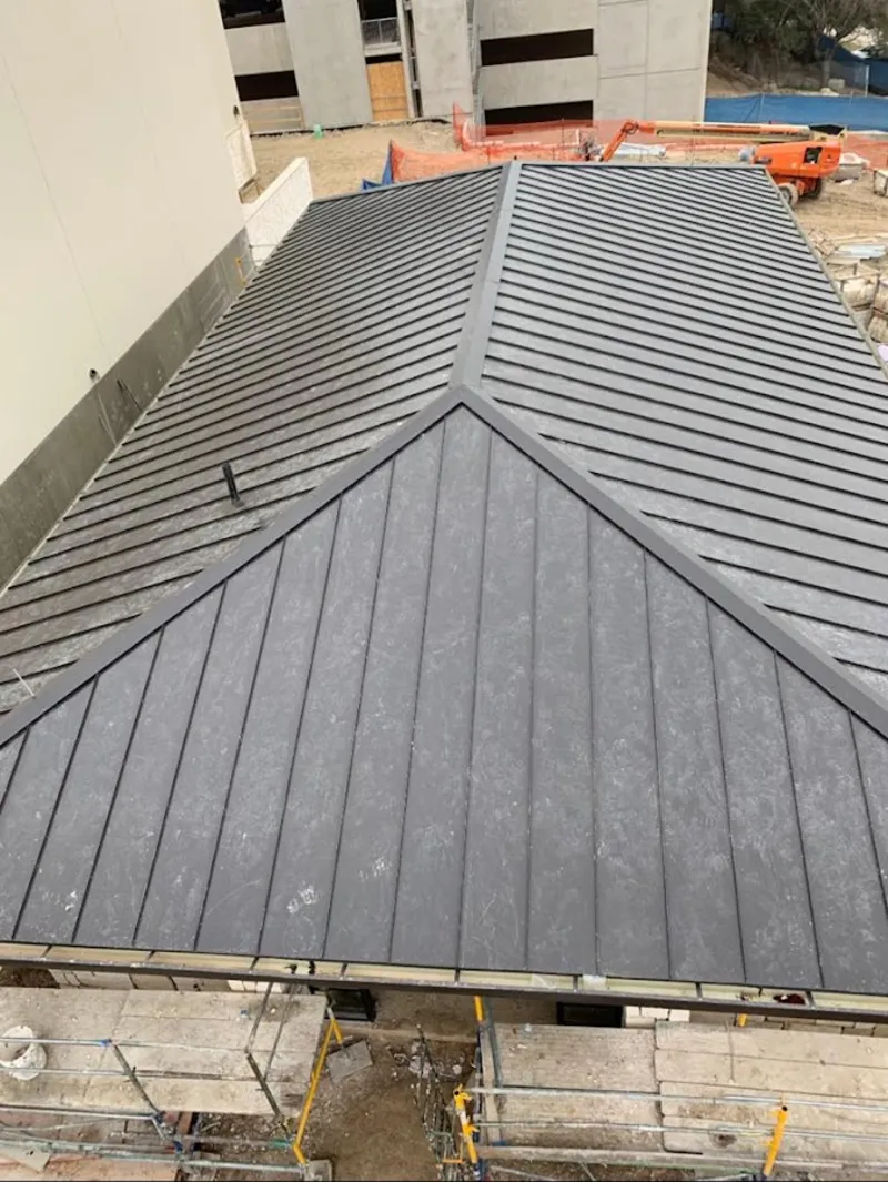 Commercial metal roof construction with crane equipment in Dickson City